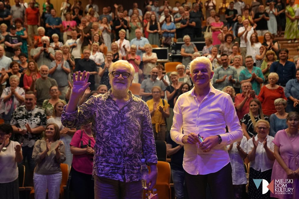 zdjęcie przedstawia aktora Andrzeja Seweryna i dziennikarza Leszka Bonara, którzy stoją na drewnianej scenie na tle publiczności