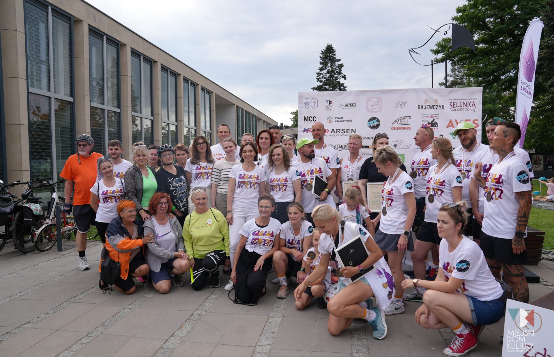 zdjęcie przedstawia ludzi, biegaczy w jasnych koszulkach, którzy brali udział w biegu na rzecz chorych onkologicznie dzieci