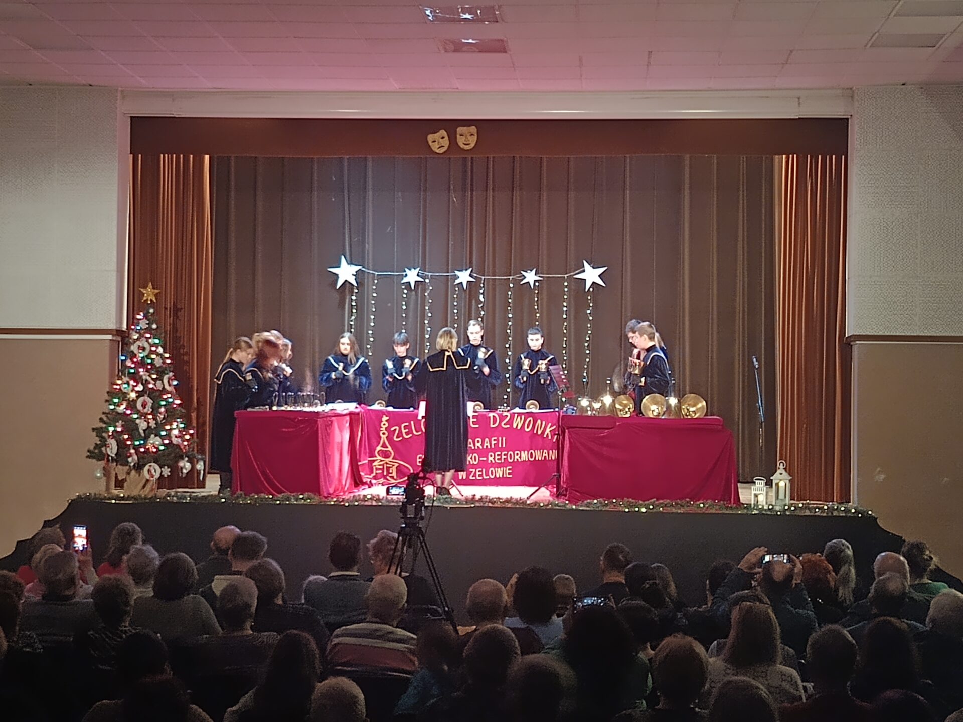 zdjęcie przedstawia salę widowiskową filii MDK os. Karsznice, a w niej kilkadziesiąt osób na widowni i zespół zelowskie dzwonki na scenie