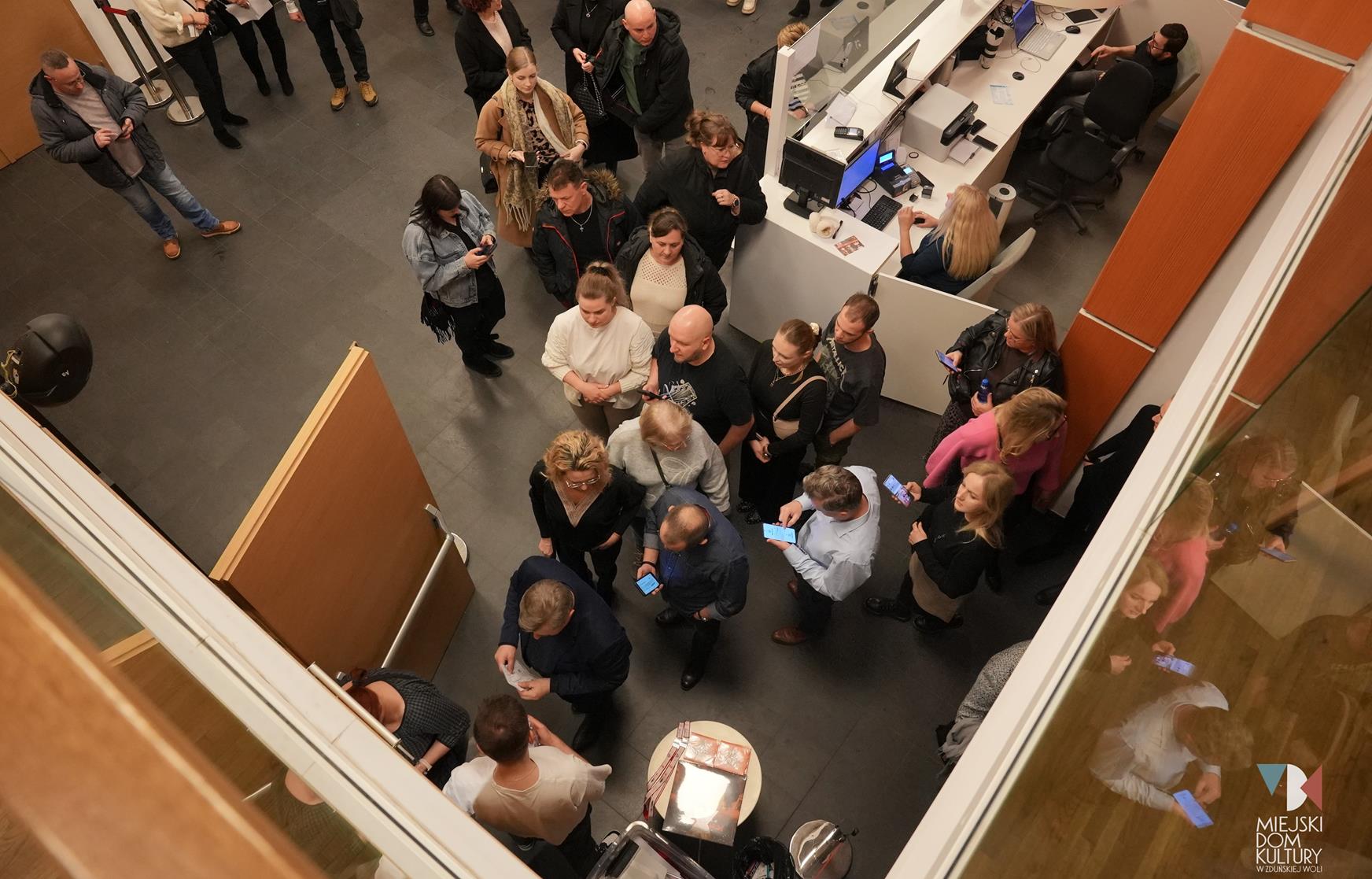 zdjęcie przedstawia kilkanaście osób, przed wejściem na salę widowiskową