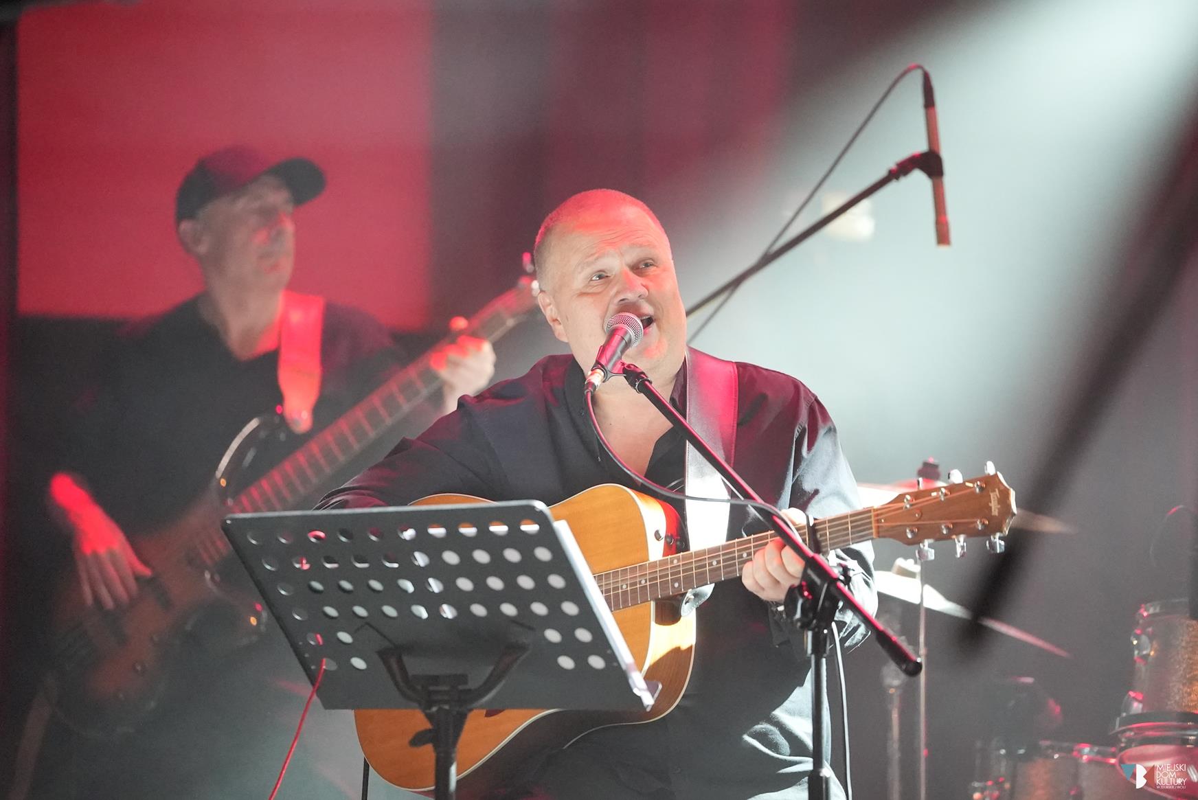 zdjęcie przedstawia Andrzeja Wawrzyniaka, z gitarą w dłoni i z mikrofonem przy ustach, to gospodarz Wieczoru z Wawrzynem