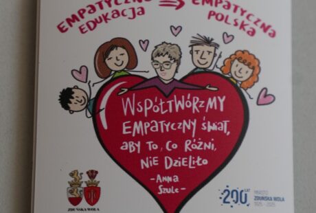 zdjęcie przedstawia biały magnes z czerwonym sercem z napisami i twarzami dzieci i zaproszeniem na Empatyczną Edukację