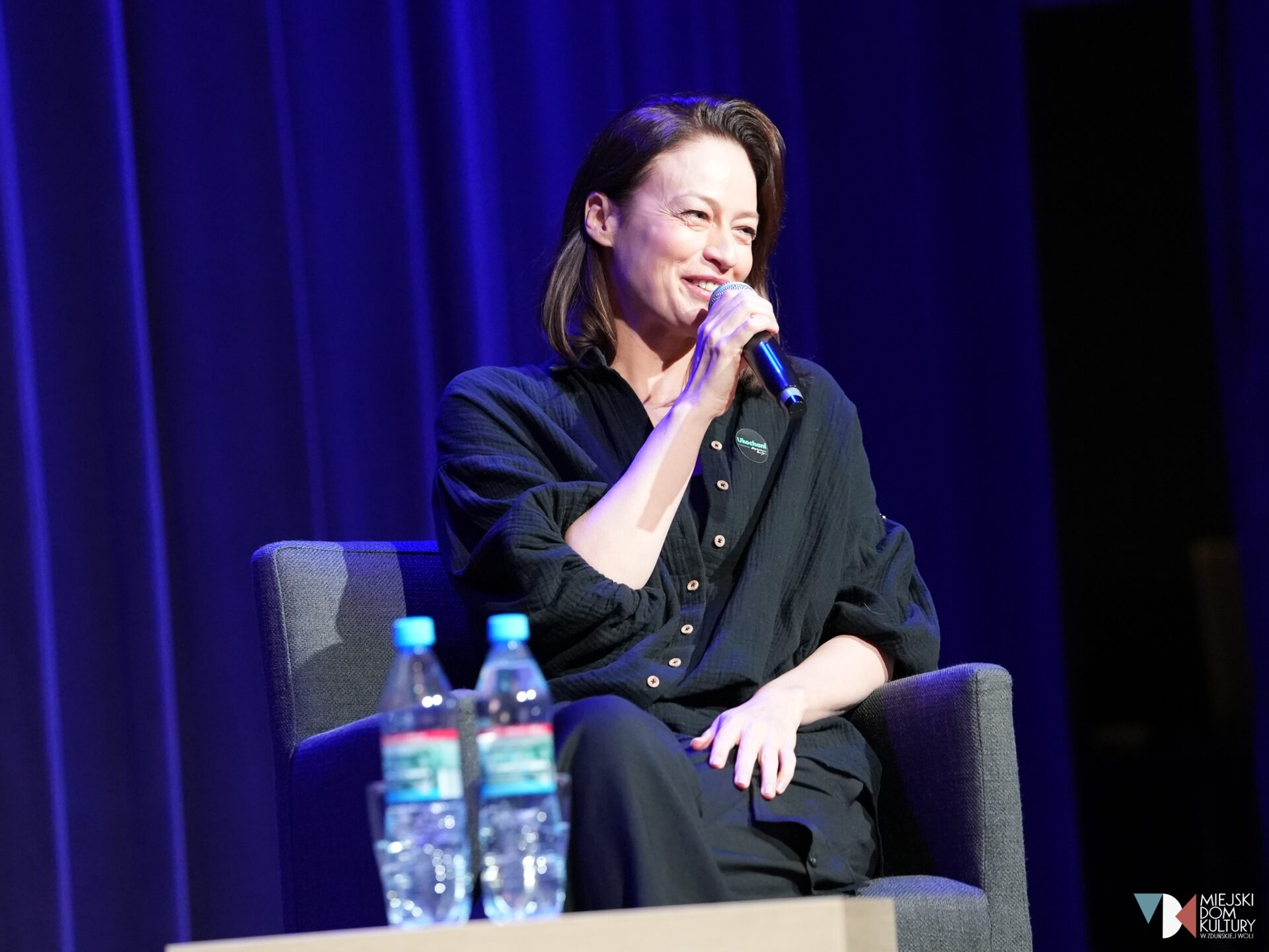 zdjęcie przedstawia polską aktorkę Magdalenę Różczkę, z mikrofonem w dłoni, kobieta w średnim wieku w ciemnych włosach