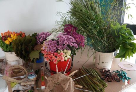 zdjęcie przedstawia kolorowe margaretki, fioletowe, żółte, białe, liliowe róże, tulipany różowe