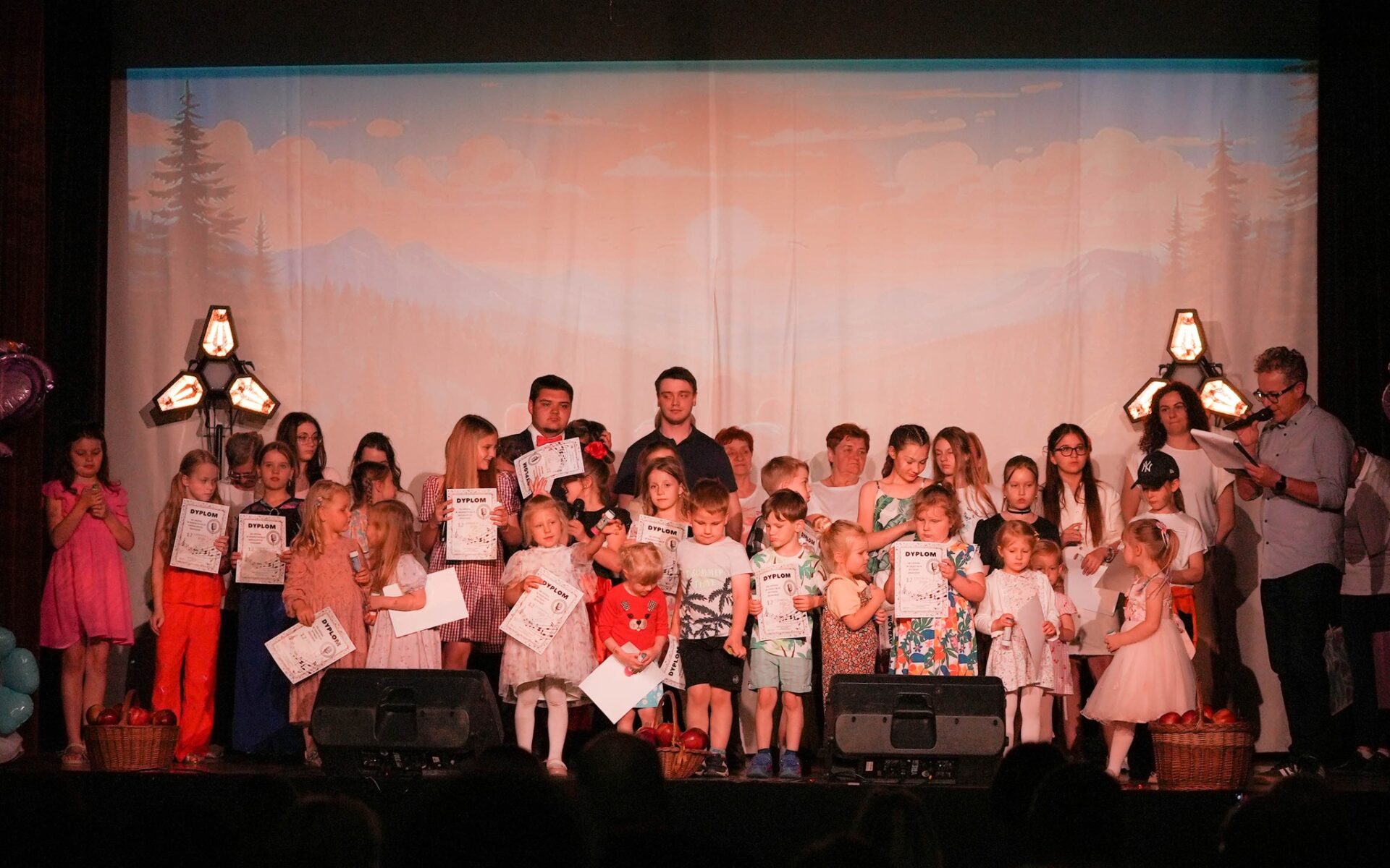zdjęci przedstawia kilkanaście osób na scenie w filii MDK, to dzieci i młodzież uczestnicy zajęć tanecznych, wokalnych
