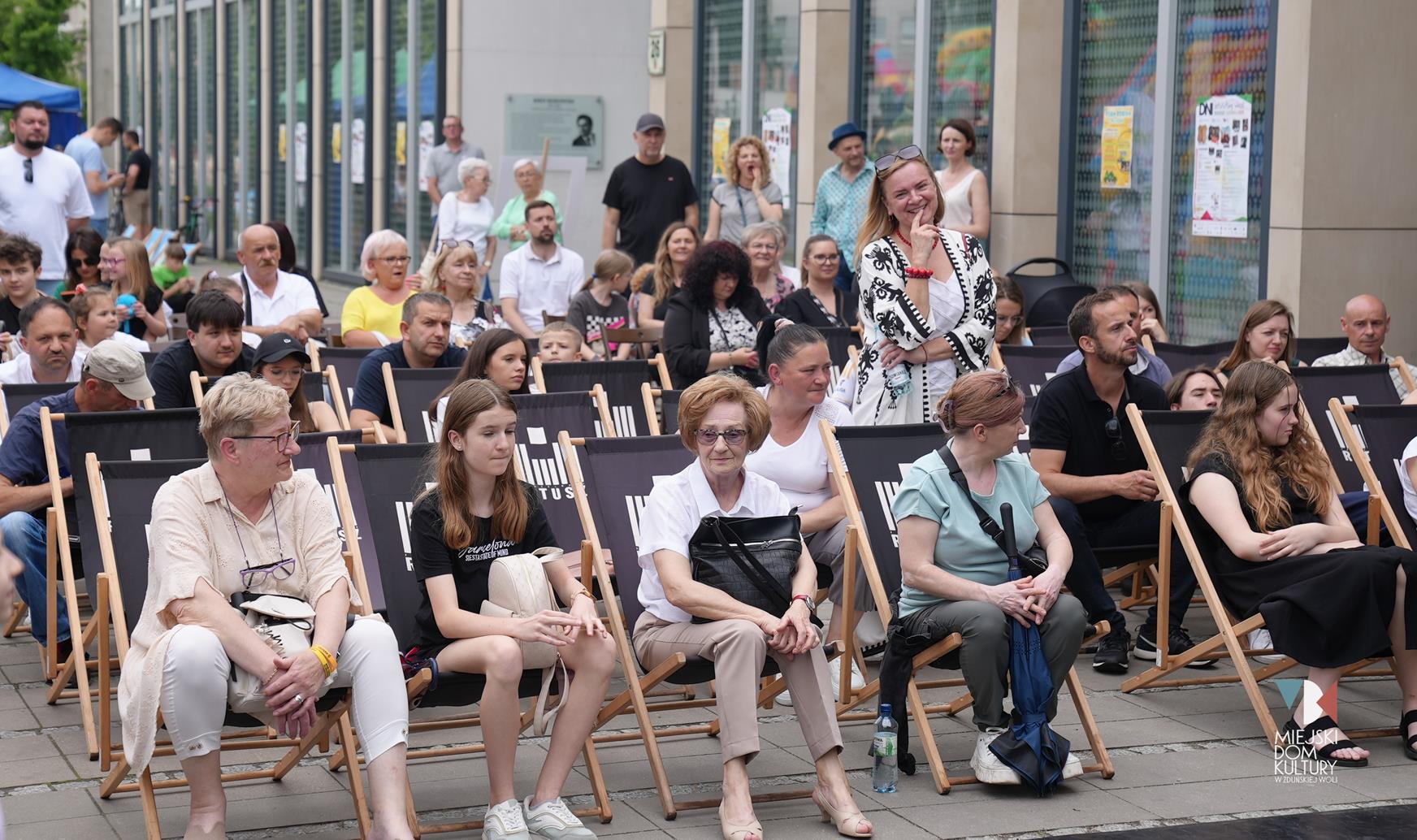 zdjęcie przedstawia publiczność siedzącą na leżakach przy Ratuszu