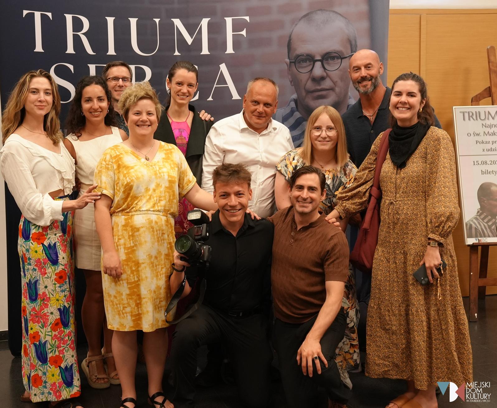 zdjęcie przedstawia kilkanaście osób, to kobiety i mężczyźni, twórcy filmu Triumf Serca, którego premiera odbyła się 15 sierpnia w Kinie Ratusz