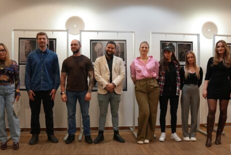 zdjęcie przedstawia kilkanaście os&oacute;b na tle prac projekt&oacute;w tatuaży