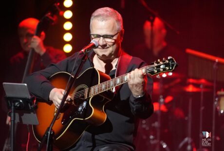 zdjęcie przedstawia Andrzeja Wawrzyniaka z gitarą ręku, starszy mężczyzna, muzyk na scenie