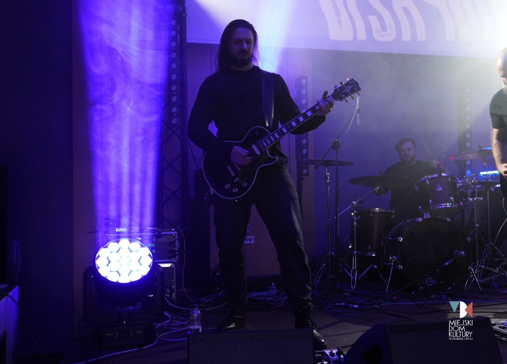 zdjęcie przedstawia gitarzystę z gitarą w ręku