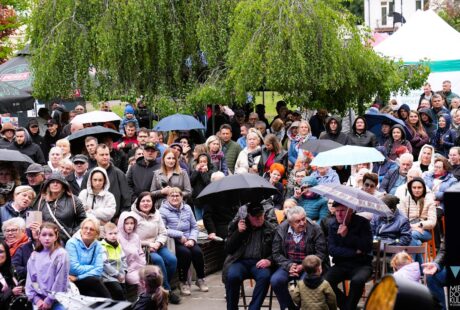 zdjęcie przedstawia tłum ludzi pod parasolami przed MDK Ratusz podczas Zdunskowolskich Dni Seniora