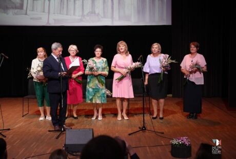zdjęcie przedstawia kilka os&oacute;b na scenie, to słuchacze Uniwersytetu Trzeciego Wieku