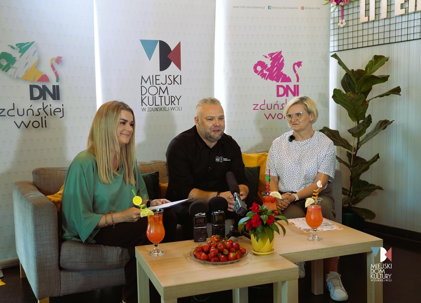 zdjęcie przedstawia trzy osoby dwie kobiety i mężczyznę w średnim wieku na szarej kanapie w kawiarni literackiej w Ratuszu