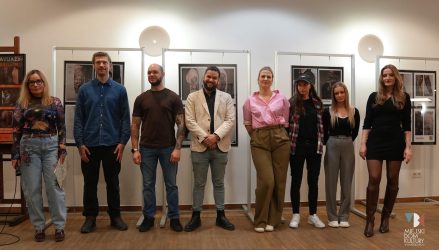 zdjęcie przedstawia kilkanaście osób na tle prac projektów tatuaży