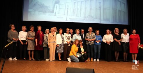 zdjęcie przedstawia kilkadziesiąt osób na scenie w Ratuszu, ubrani są elegancka, na galowo, to seniorzy, osoby starsze, które rozpoczną naukę na UTW w Zduńskiej Woli